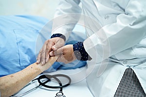 Doctor holding touching hands Asian senior or elderly old lady woman patient with love, care, helping, encourage and empathy.