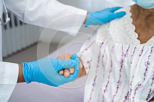 Doctor holding touching hands Asian senior or elderly old lady woman patient with love, care, helping, encourage and empathy at