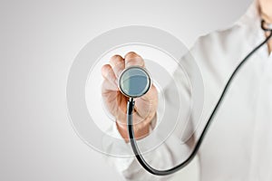 Doctor holding up the disc of a stethoscope