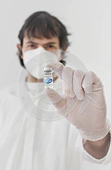 Doctor holding a vaccine bottle and syringe, beginning of mass vaccination with the Pfizer-BioNTech COVID photo