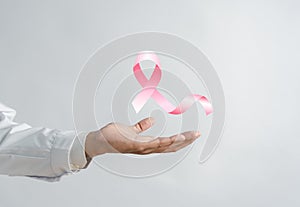 Doctor holding virtual pink ribbon cancer, Breast cancer awareness
