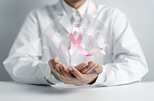 Doctor holding virtual pink ribbon cancer, Breast cancer awareness