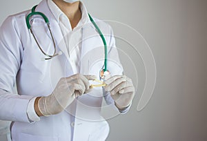 Doctor holding yellow umbilical cord clamp used to clamp off the