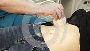 Doctor holds an abdominal ultrasound to the patient in the hospital.