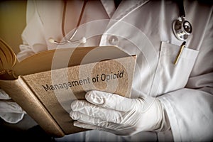 Doctor holds book on Management of Opioid photo