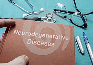 Doctor holds book on neurodegenerative Diseases in a hospital