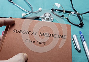 Doctor Holds Book On Surgical Medicine In A Hospital