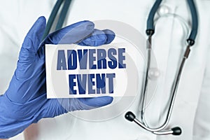 The doctor holds a business card that says - ADVERSE EVENT
