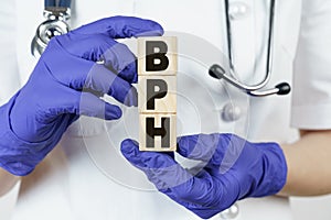 The doctor holds cubes in his hands on which it is written - BPH. Benign prostatic hyperplasia