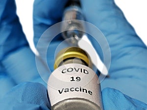 The doctor holds a glass vial of  vaccine for corona virus and  fills a syringe.