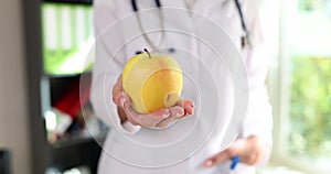 Doctor holds in hand ripe yellow pear in clinic