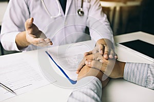 Doctor holds hands and leaves comforting counselors to patient