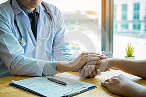 Doctor holds hands and leaves comforting counselors to patient photo