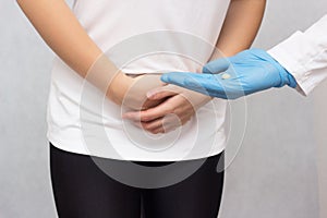 The doctor holds in his hand an anesthetic pill for menstruating a girl against pain, close-up, pain reliever