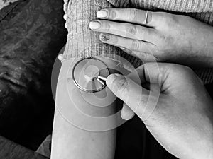 The doctor holds in his hand a medical stethoscope, phonendoscope and listens to the pulse, measures the pressure on the hand