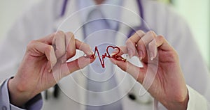 Doctor holds in his hands an icon with cardiogram of heart