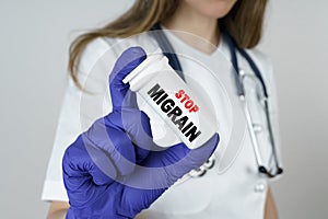 The doctor holds a medicine in his hands  which says - STOP MIGRAIN