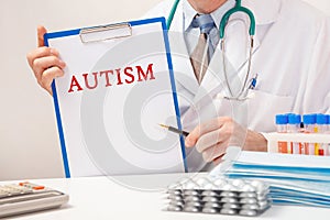 Doctor holds paper with inscription AUTISM