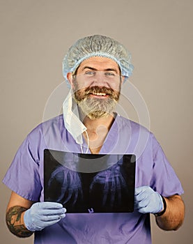 Doctor holds pictures of bones. Fracture and bone damage. Doctor examines radiographic snapshot of wrist. Surgeon photo