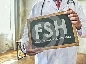 Doctor holds sign FSH Follicle stimulating hormone.