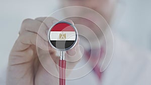 Doctor holds stethoscope bell with the Egyptian flag. Healthcare in Egypt