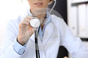 Doctor holds stethoscope head, closeup. Physician ready to examine and help patient. Medical help and insurance in