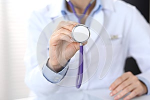 Doctor holds stethoscope head, closeup. Physician ready to examine and help patient. Medical help and insurance in
