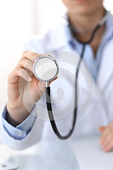 Doctor holds stethoscope head, closeup. Physician ready to examine and help patient. Medical help and insurance in