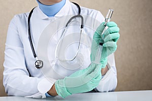 Doctor holds vial of medicine and syringe