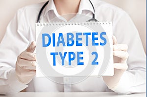 Doctor holds a white sheet of paper and points to the text diabetes type 2, medical concept