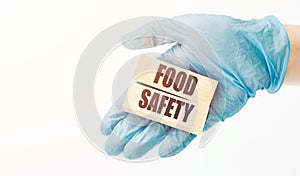 A doctor holds wooden cubes on his hand with the text food safety, medical concept