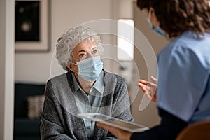 Doctor home visit a senior woman during the covid-19 pandemic photo