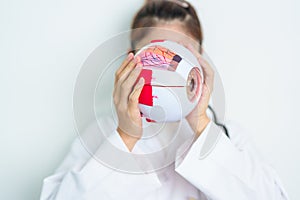 Doctor with human Eye anatomy model with magnifying glass. Eye disease, Refractive Errors, Age Related Macular Degeneration,