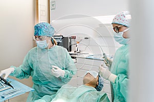 Doctor and hygienist prepare before operating on the patient in the dental clinic