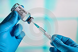 Doctor preparing a dose of the vaccine for Virus Influenza Flu Grippe photo