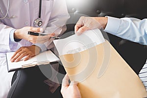 Doctor informing patient`s of diagnosis medical record from paper in hospital