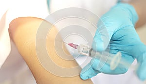 Doctor injecting drug dose into his arm by using syringe.  Drug addict injecting drugs concept