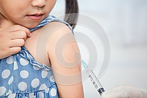 Doctor injecting vaccination in arm of asian little child girl