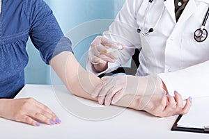 Doctor injecting woman's hand photo