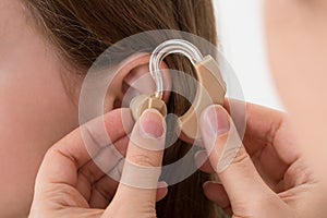 Doctor Inserting Hearing Aid In The Ear Of A Girl