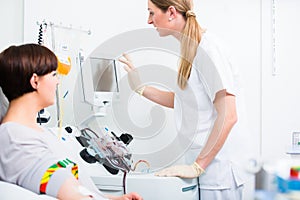 Doctor in intensive medical care checking results of woman patient