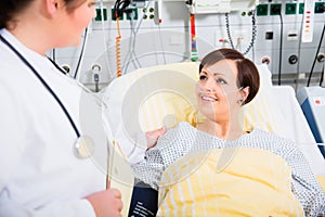 Doctor in intensive medical care checking results of woman patient