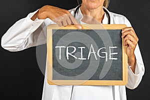 Doctor keeps a blackboard with the text "Triage" photo