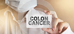 Doctor keeps a card with the name of the diagnosis - colon cancer. Selective focus. Medical concept