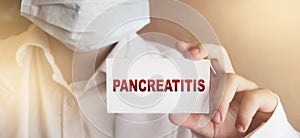 Doctor keeps a card with the name of the diagnosis pancreatitis. Selective focus. Medical concept