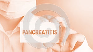 Doctor keeps a card with the name of the diagnosis pancreatitis. Selective focus. Medical concept