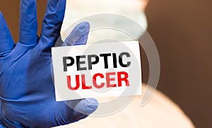 Doctor keeps a card with the name of the diagnosis peptic ulcer. Selective focus