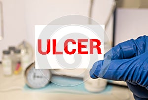 Doctor keeps a card with the name of the diagnosis - peptic ulcer. Selective focus