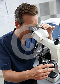 Doctor in lab making analyse with microscope