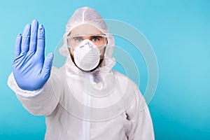 Doctor or lab scientist wearing biohazard protective suit hand gesturing Stop Coronavirus COVID-19 disease global